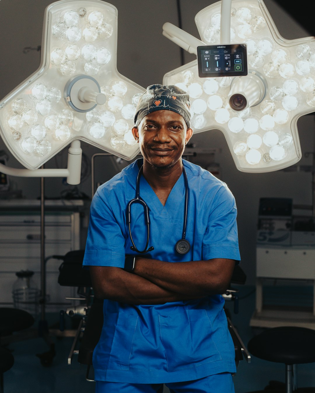 Surgeon in blue scrubs preparing for surgery in a sterile operating room.